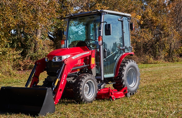 Massey Ferguson 1M Series compact tractor with cab and front loader on grassy field.