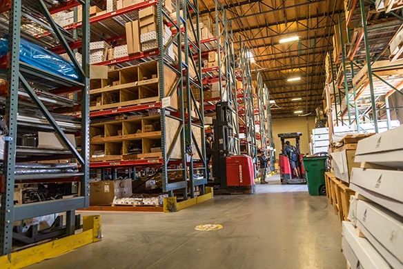 Interior view of Quinn Ag’s parts warehouse in California, with tall shelving units stocked with agricultural equipment components.